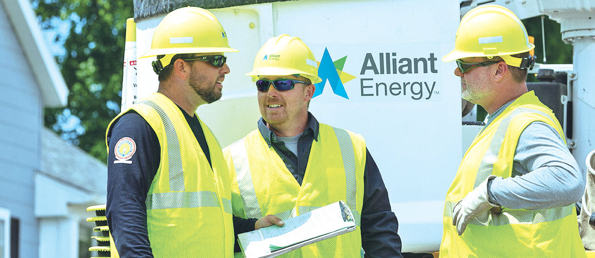 three employees in hardhats talking