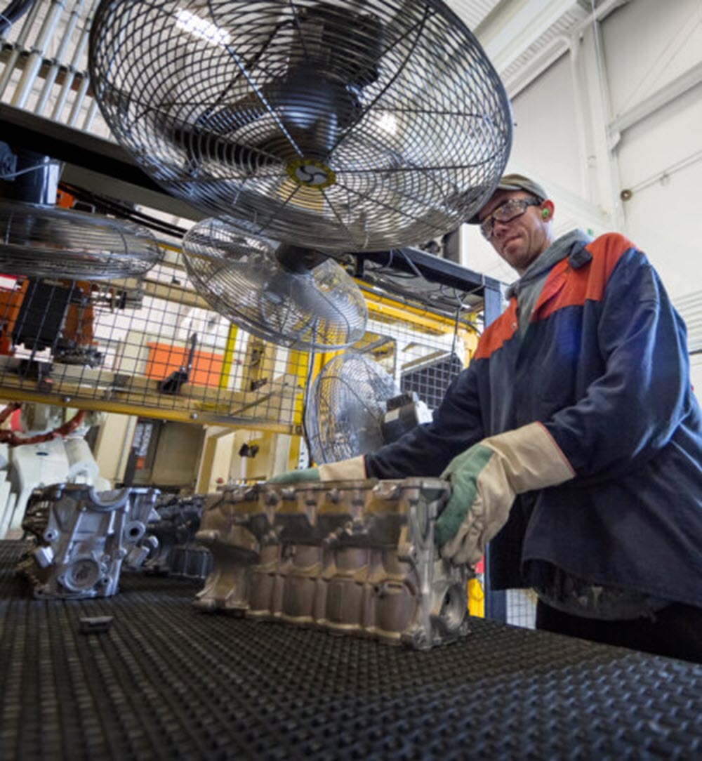 person working on an engine in a factory