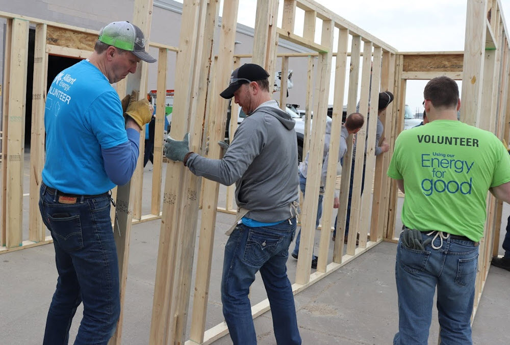 Alliant Energy employee volunteers raising a wall frame