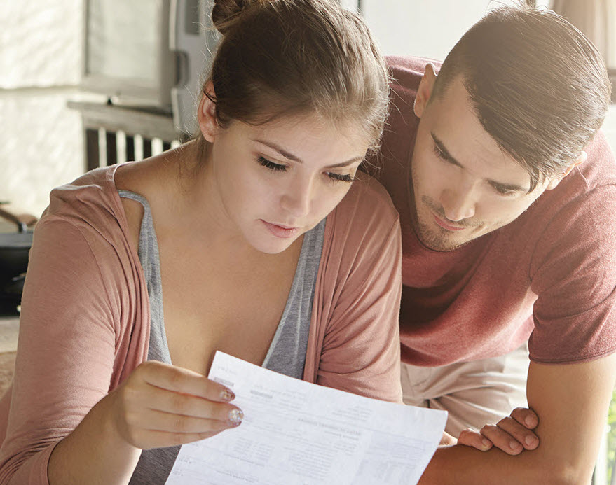 young couple looking at bill