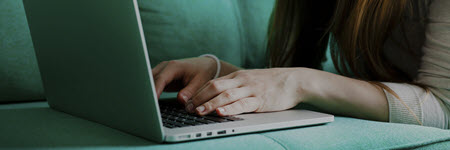 A woman typing on a laptop